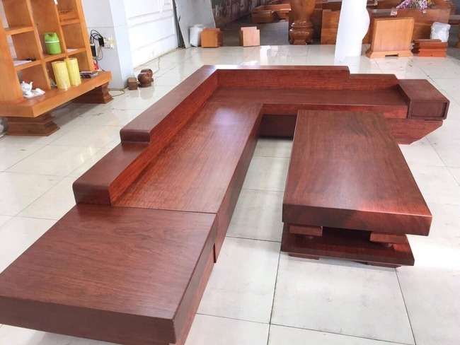 Mẫu sofa gỗ lim đỏ dáng dài chữ L phù hợp cho không gian phòng khách của biệt thự, nhà vườn